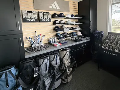 A display of hats, golf bags, and other equipment at a shop.