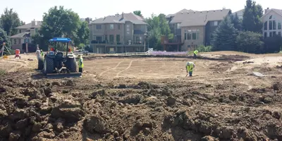 A crew and equipment working in an empty field.