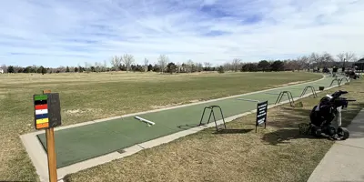 A driving range at a golf course on a sunny day