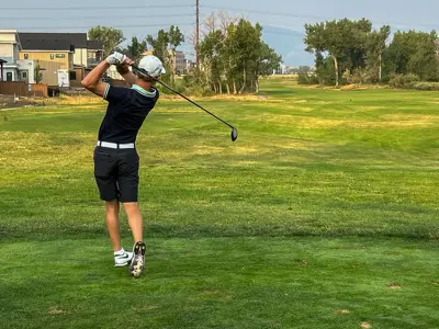 A young man hitting a golf ball